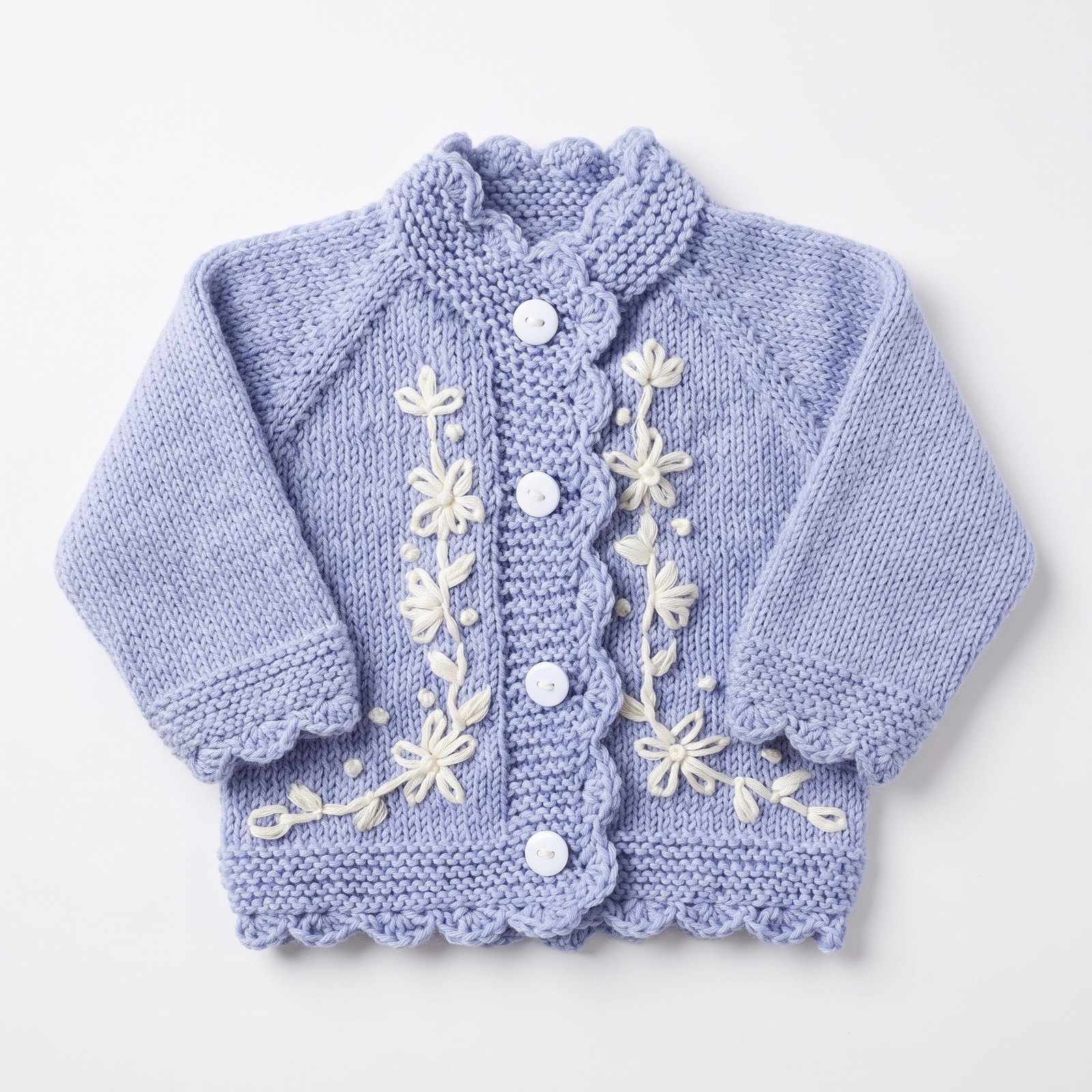 Periwinkle blue hand-knit baby cardigan and bonnet with embroidered white daisy vines and scalloped edges